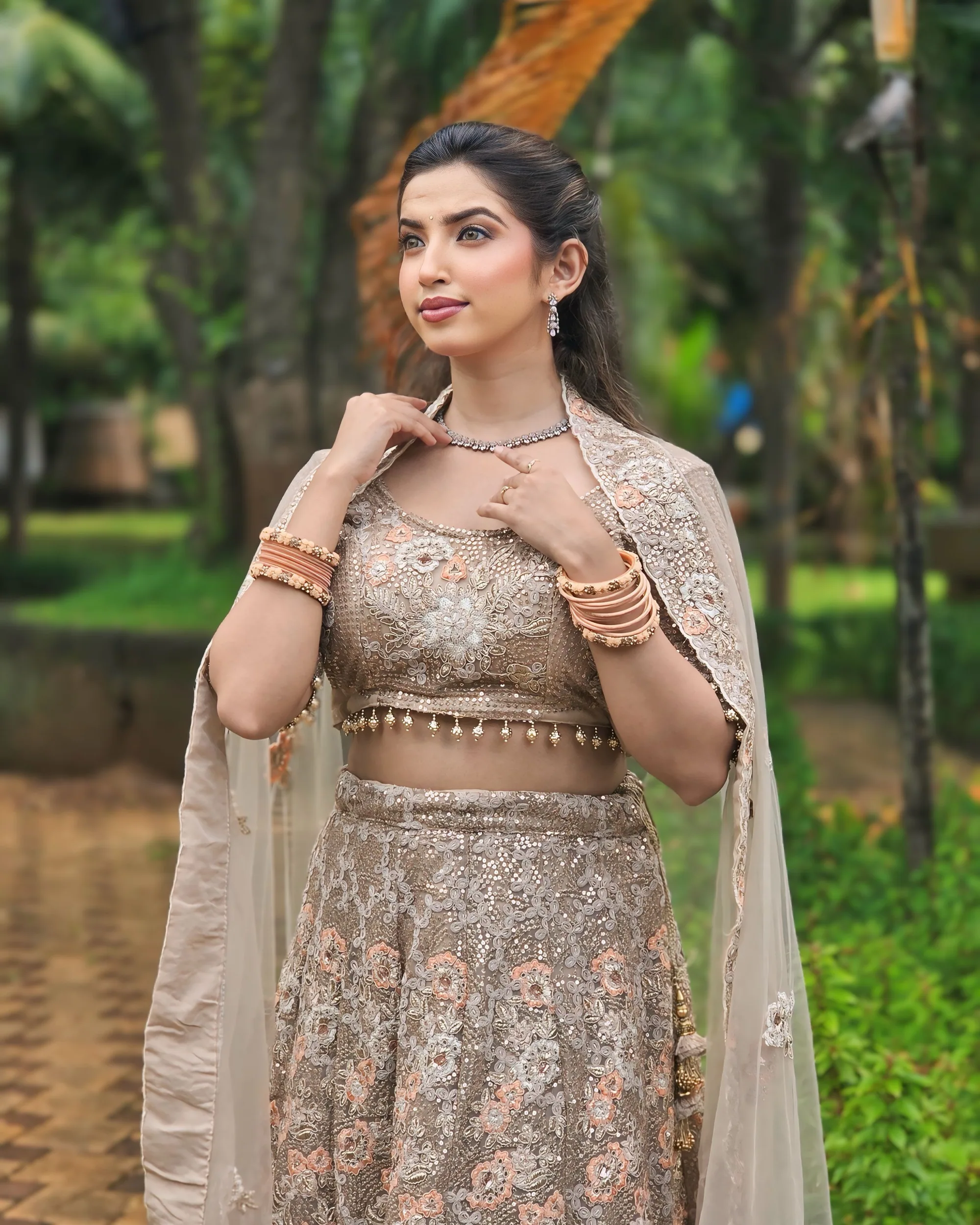 Beige and gold lehenga with a net cape, photographed in daylight