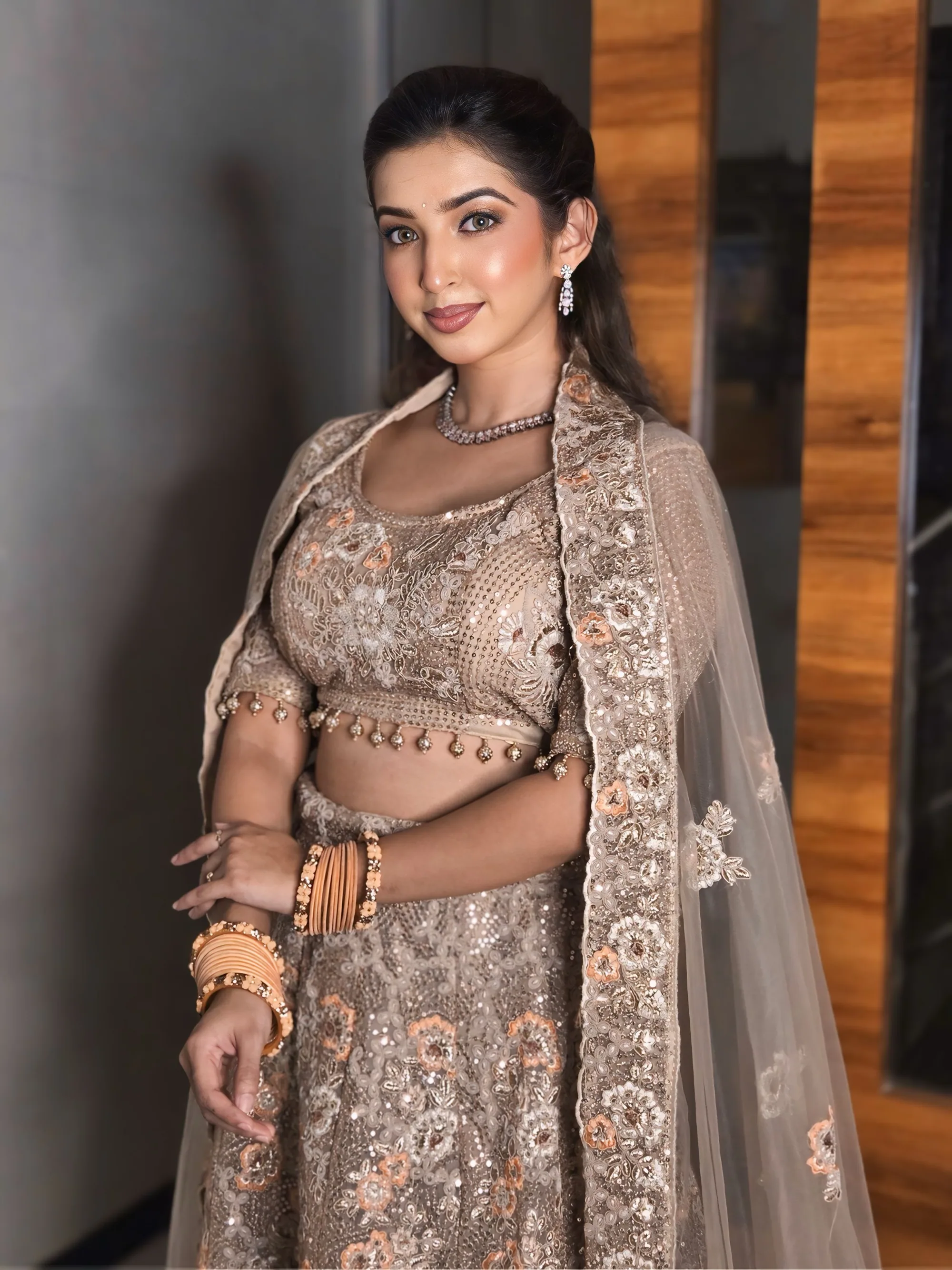 Bride in a beige and gold lehenga photographed outdoors