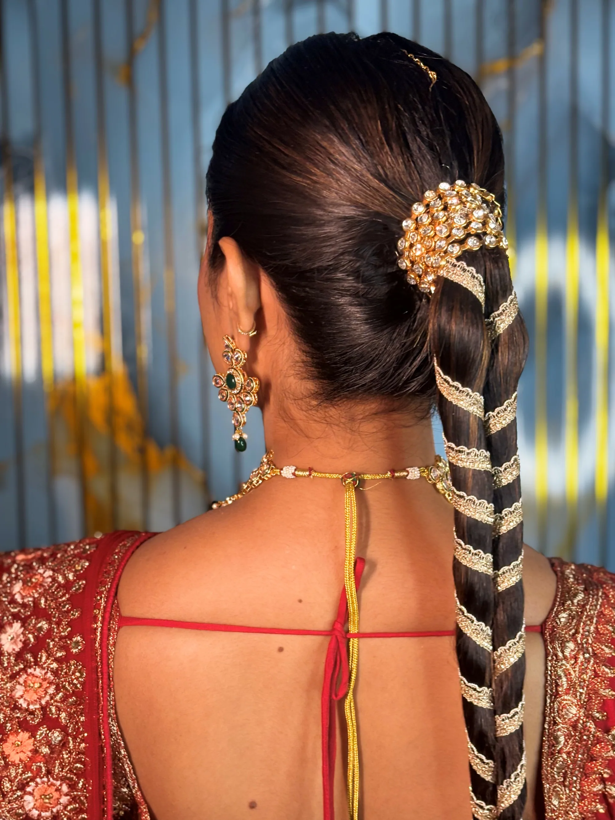 Sleek bridal ponytail wound with gold gota lace