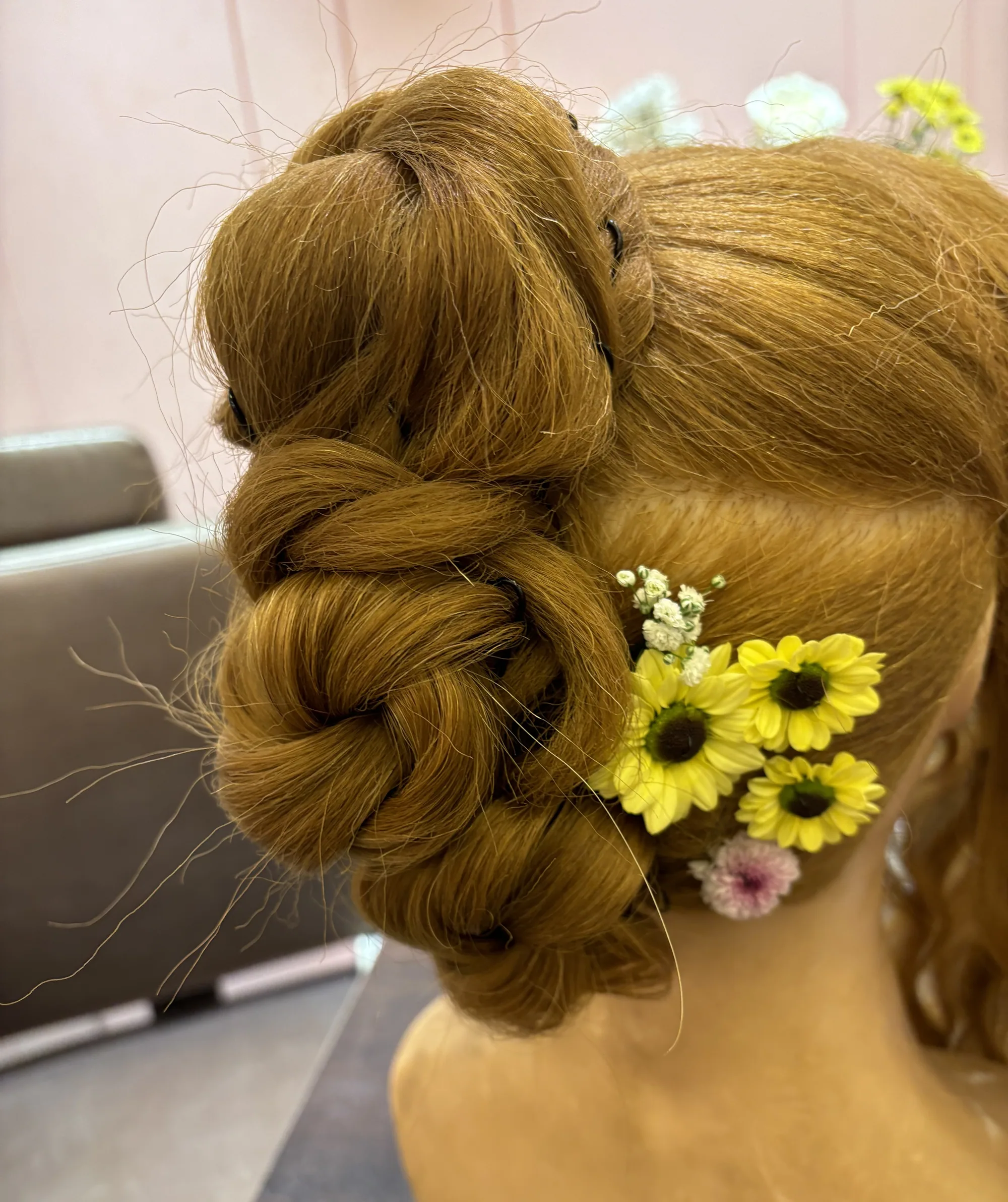 Knotted bridal bun with daisies, practised on a mannequin