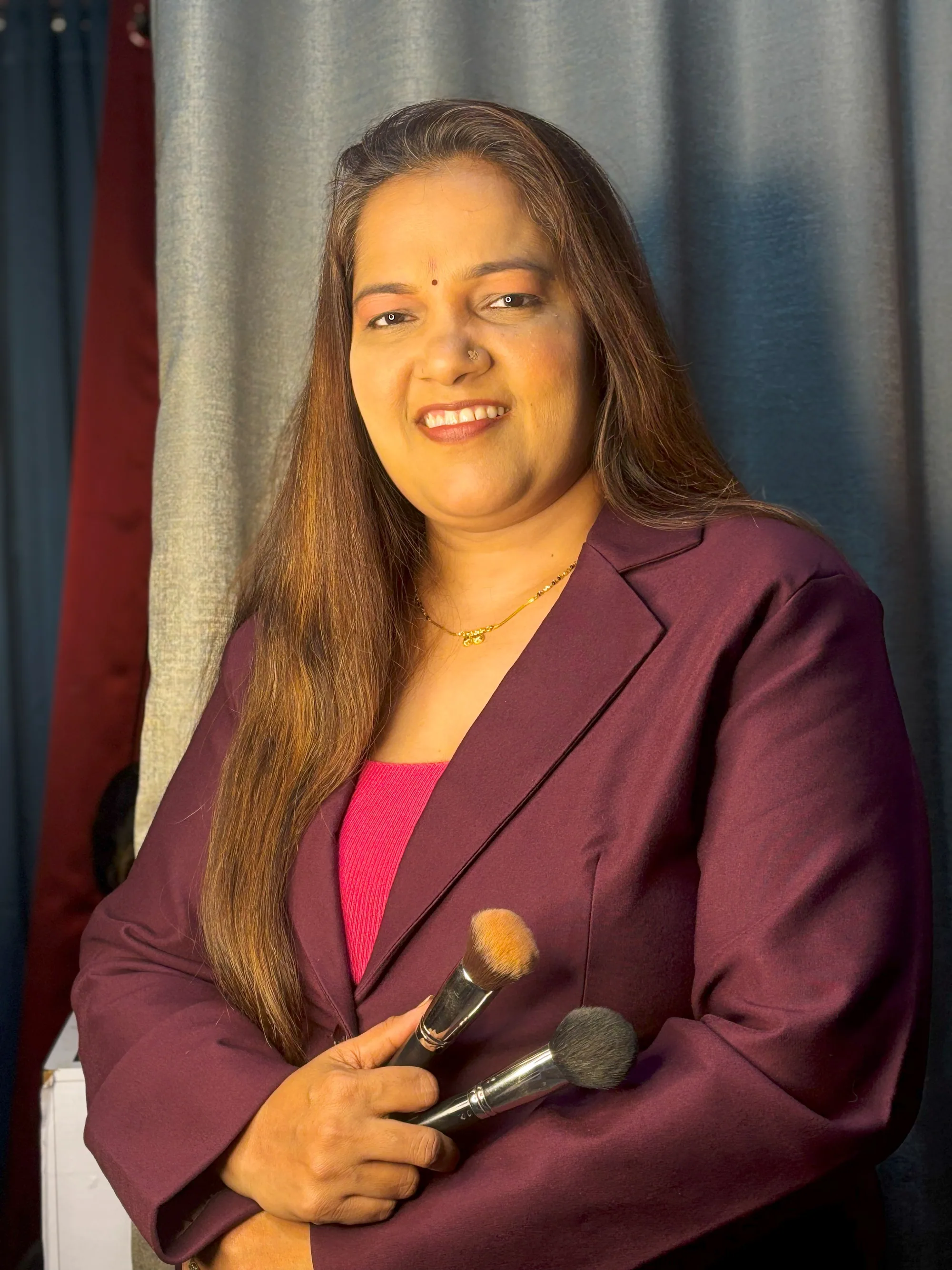 Neha Gujar holding two makeup brushes