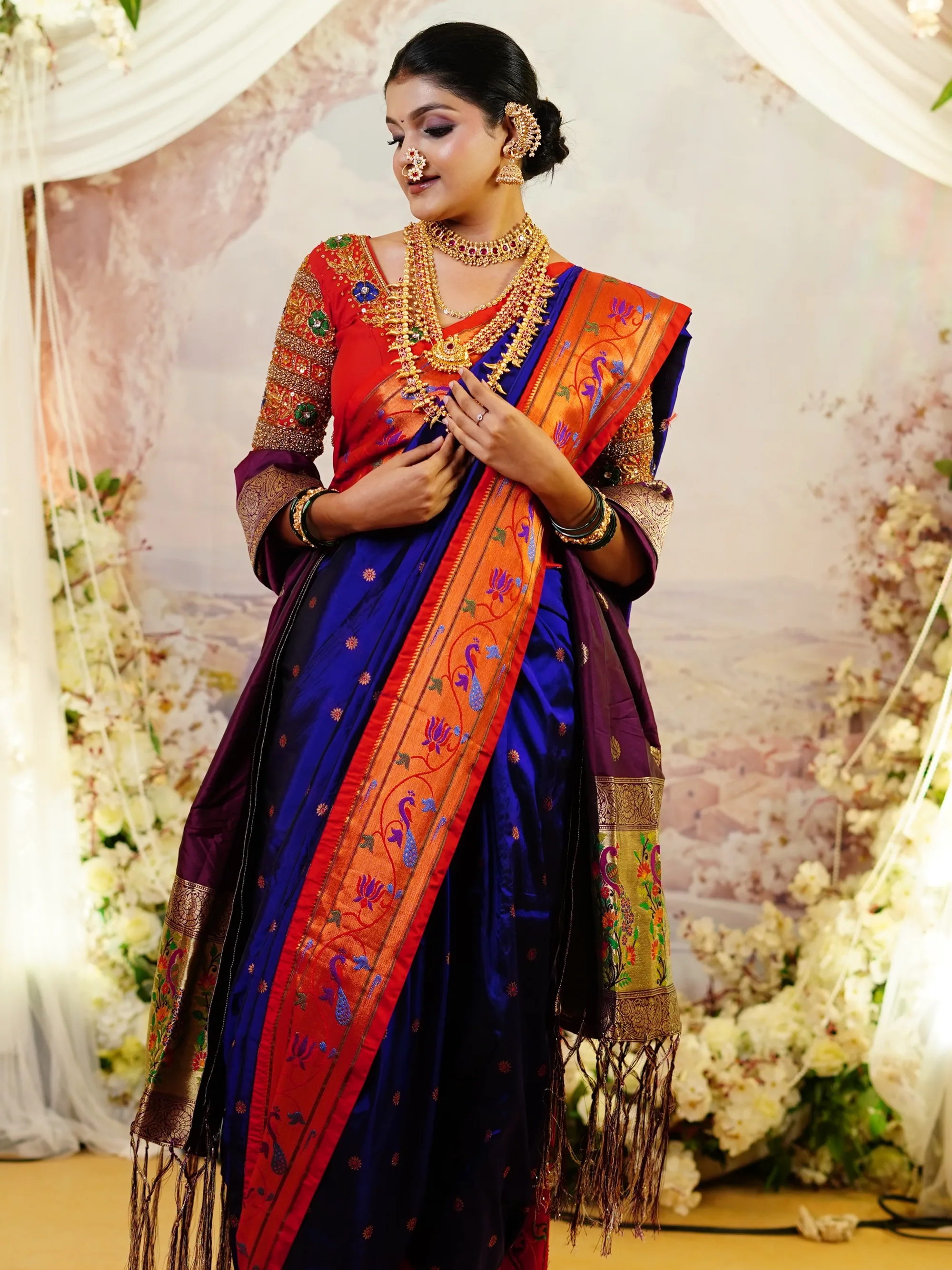 Paithani nauvari bride, hand raised, green foliage behind